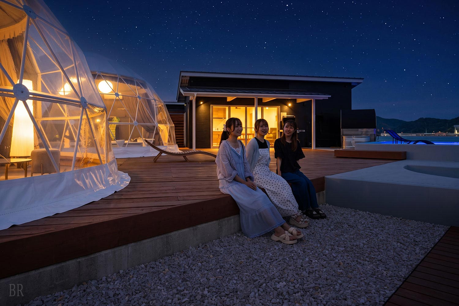Women chatting together at night at GLAMP DOME SHIMONOSEKI